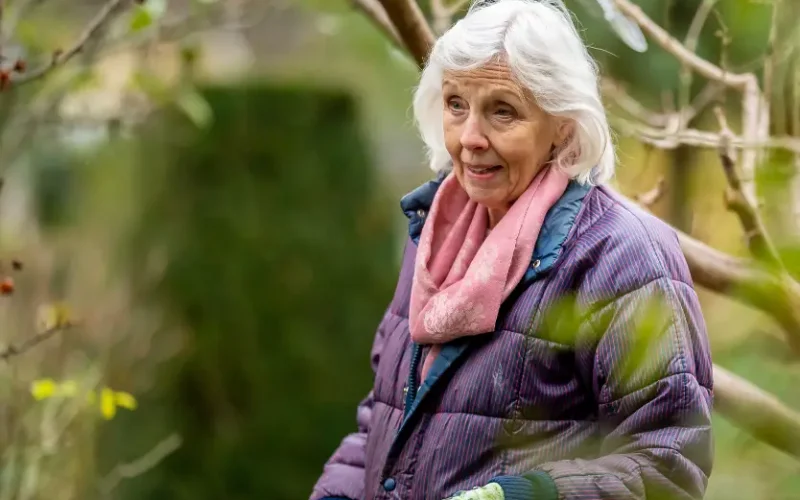 How to get started when you become a carer An older woman standing by a tree